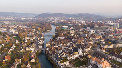 Drone view of cityscape Brugg north-east with Aare river, residential and commercial districts, historic old town and casino bridge in canton Aargau in Switzerland. Town situated on feet of Tafeljura.