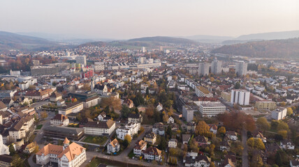 Obraz premium Drone view of cityscape Brugg with residential and commercial districts, historic old town and Windisch in canton Aargau in Switzerland. Town situated on feet of Tafeljura.