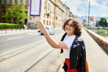 Fototapeta premium Woman hand gesture stopping taxi in modern city