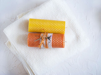Two handmade candles lie on a white towel. Holiday gift