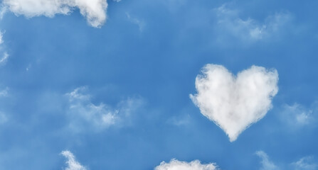 Naklejka na ściany i meble Heart shaped clouds over blue sky