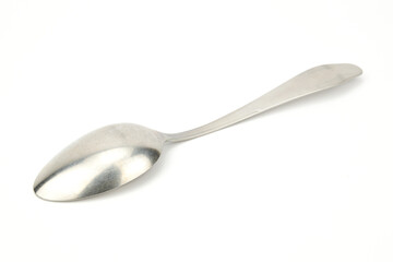 A tablespoon lying on the diagonal of the image, bottom up.