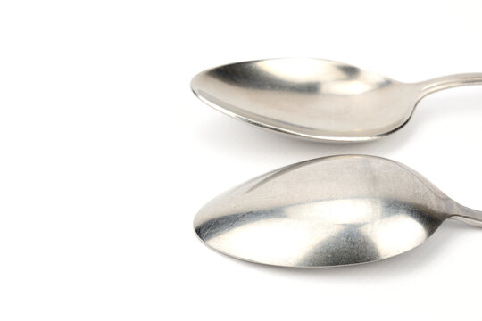 Side view of two tablespoons. One lies with the bottom up, the other down.
