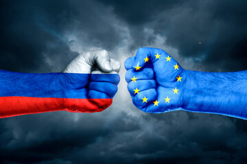 Flags of EU and Russia painted on two fists on sky background. EU versus  Russia trade war disputes concept.