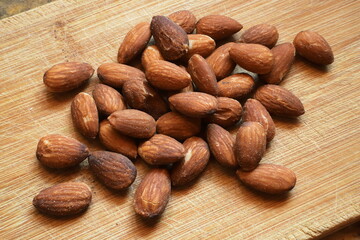 Pile of salted, roasted almonds on a wooden board