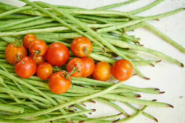 chauchas metro y tomates cherri, vegetales frescos sobre fondo blanco 