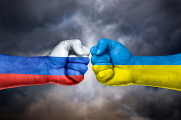 Flags of  Russia and Ukraine painted on two fists on sky.  Russia versus  Ukraine trade war disputes concept. Sanctions policy 