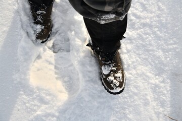 The hunter walks in the snow in a shoe resistant to snow and ice