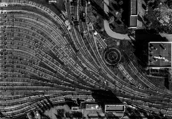 aerial drone creative top view to metro depot heavy rail, subway, tube, metropolitana or underground. Black and white square design composition. Abstract representation of public transport industry 