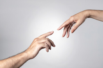 a man's and a woman's hand touching each other with their fingertips