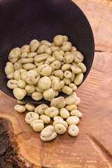cranberry berries in white chocolate spilling out of a dark cup onto a wooden background