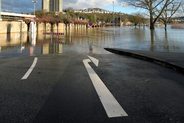 Großer Pfeil Richtung rechts auf der Straße und Überflutung an Parkplatz bei Hochwasser am Rhein...
