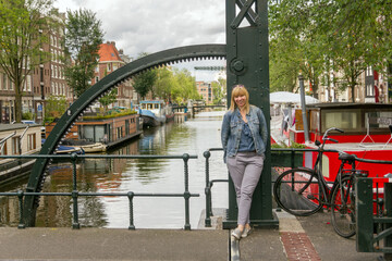 Woman standing on a bridge in Amsterdam. Travel, tourism and city concept.