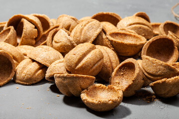 Fototapeta na wymiar Homemade cookies nuts with condensed milk on wooden table. Pile of cookies in walnut form.