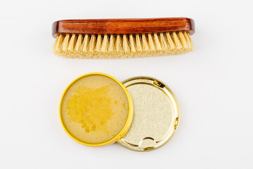 Shoe brush and shoe cream jar are isolated on a white background.