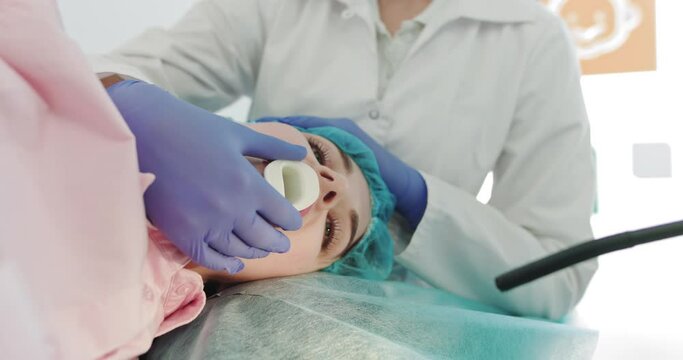 Doctor Makes An Endoscopy Through The Mouth Of A Young Girl, Pulls Out A Tube Gastroscope. Apparatus For Endoscopy And Manipulations In Otolaryngology. Modern Equipment During The Operating Process