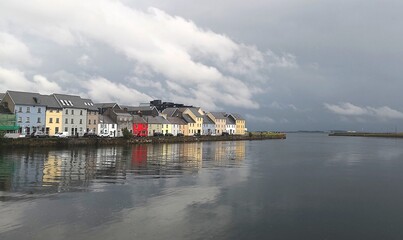 Fototapeta premium Colourful houses by the ocean in Galway, Ireland ona a cloudy day