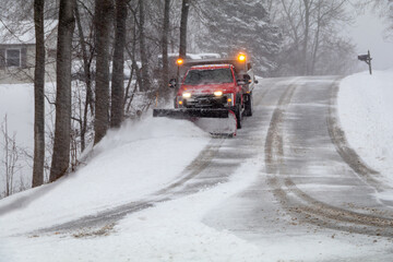 Snowplow in action clearing residential roads during snow storm