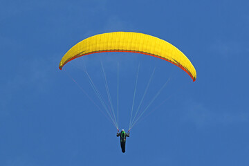 Paraglider flying wing in a blue sky	