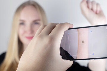 The woman shows his hand with a chip implanted which is read or scanned by a special device....
