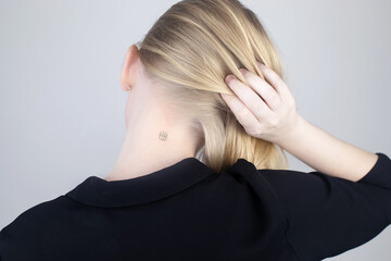 The woman shows his neck with a chip implanted. The concept of chipping and implantation of...