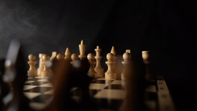 Close up of white and black chess pieces on board. Selective focus on first move of white pawn on chessboard. Concept of intelligent, logical and strategic game.