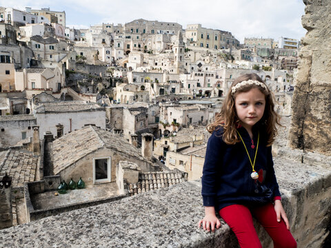 Portrait of a girl sitting on a wall, Matera, Basilicata, Italy