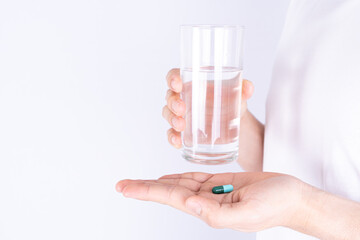 Close up hands holding glass of water and pill drugs. Healthcare and medical pharmacy concept.