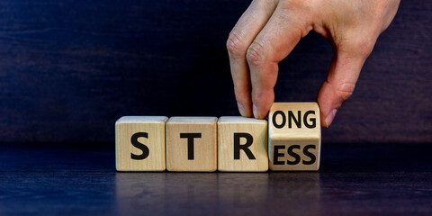 Strong stress symbol. Businessman turns wooden cubes with words 'strong stress'. Beautiful grey background, copy space. Business and strong stress concept.