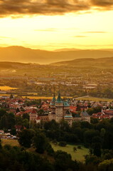 Fototapeta premium Beautiful aerial view on Bojnice castle and town of Bojnice in a warm yellow light at sunrise