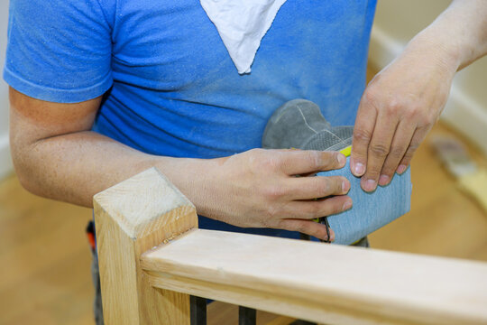 Wooden railing sanding with sandpaper for stairs grinder work on timber wood
