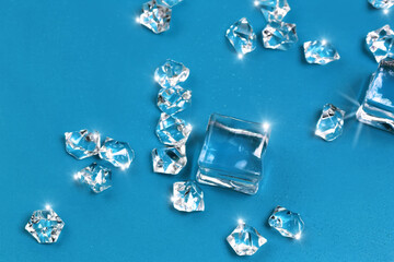 Abstract blurred background of shining ice cubes on a blue backdrop.