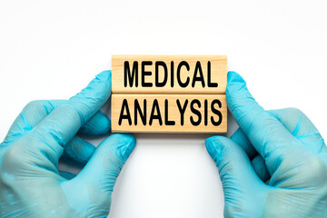 The doctor's hands show the words medical ANALYSIS . a gloved hand on a white background. Medical concept. the medicine