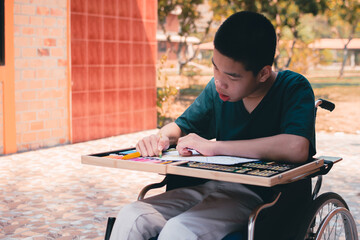 Asian disabled child on wheelchair coloring art work,The skills to practice muscle development,Special children's lifestyle,Life in the education age of special need kids,Happy disability kid concept.