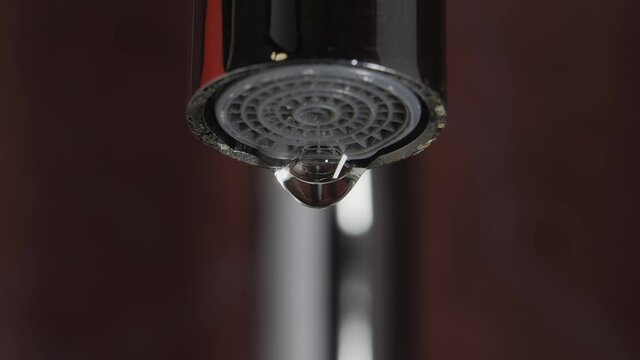 Water flows from the aerator of the tap of the water mixer. Drop formation. Drop of water drop. Close-up.