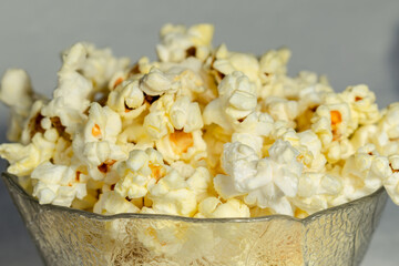 Salted popcorn on a light background. Close-up.
