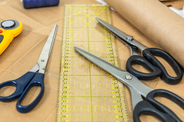 Top view of dressmaker's work table. Patterns on paper, scissors, thread and marker.