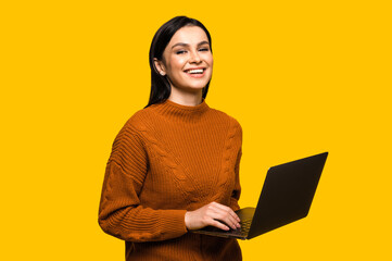 Satisfied attractive young caucasian smiling woman in casual sweater, stands on isolated orange...