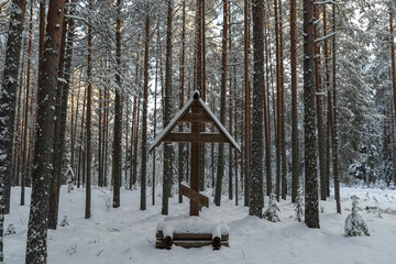 Orthodox symbol in the pine forest in winter.