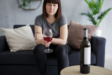 young woman drinking red wine at home