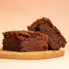 Front view of a pair of delicious chocolate brownies on a wood with a light background. Magic brownies