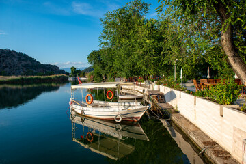 Obraz premium June13, 2020. Dalyan, Mugla - Turkey. Boats view at slope of Lycians rock tombs in Dalyan Town.