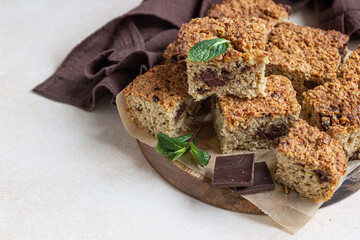 Oatmeal squares with chocolate decorated, light concrete background. Diet bars. Healthy bakery for breakfast or dessert.