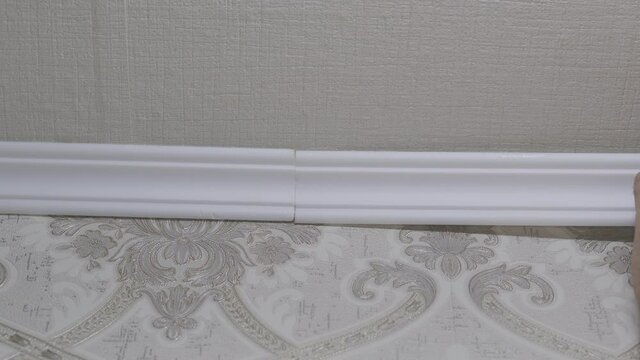 Installation of a ceiling skirting board on liquid nails to a ceiling, a wall.