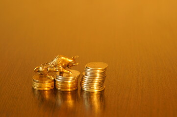 A bull figurine with coins on the table.