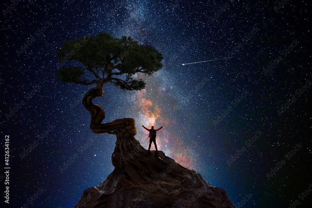 Wall mural man under a tree in front of the universe