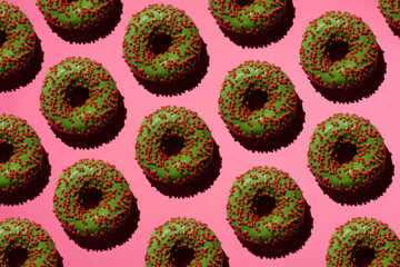 Green donuts with red crumb on a pink background