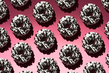 White donuts with black crumb on a pink background