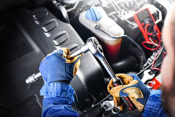 Fototapeta premium Auto mechanic working on car broken engine in mechanics service or garage.