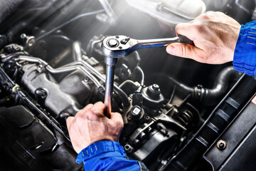 Auto mechanic working on car broken engine in mechanics service or garage.